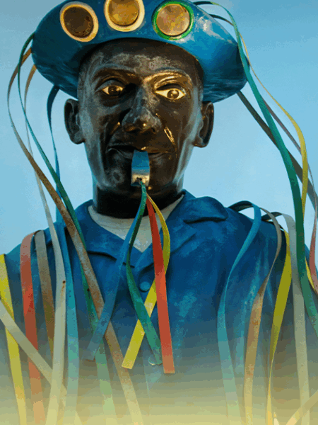 Estátua de cangaceiro com chapéu tradicional e fitas coloridas representando a cultura nordestina brasileira.