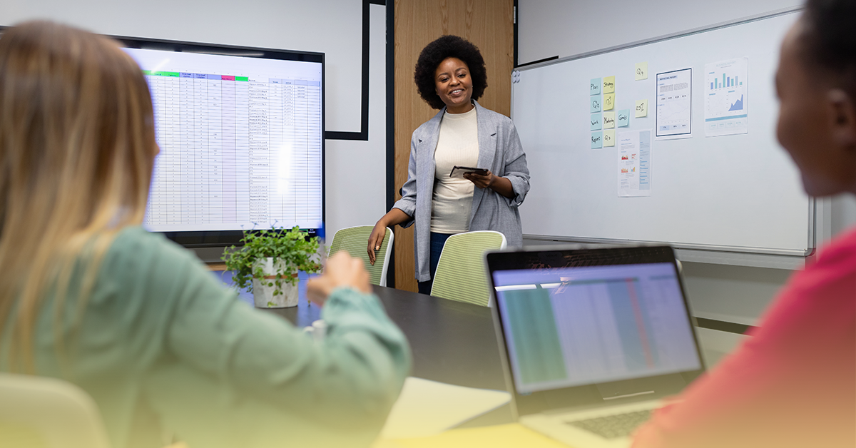 Equipe pedagógica em reunião analisando planilhas e indicadores educacionais para definir prioridades pedagógicas e estratégias para o ano letivo de 2026.