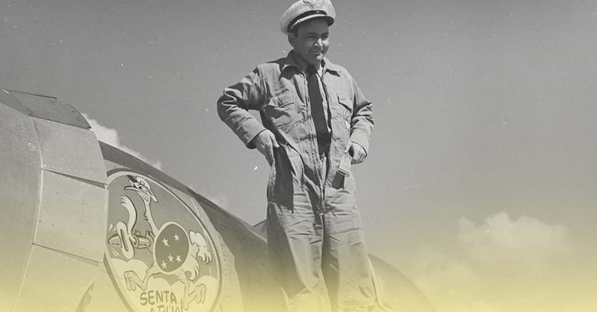 Militar da Força Aérea Brasileira ao lado de aeronave com o emblema “Senta a Pua”, durante a Segunda Guerra Mundial.