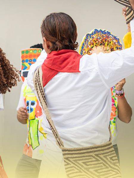 Pessoas com fantasias coloridas e máscaras celebrando o Carnaval, representando as raízes históricas e culturais da festa no Brasil.