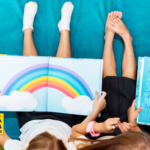 Crianças lendo livros infantis coloridos juntas, deitadas no chão, explorando histórias ilustradas que estimulam a imaginação e o desenvolvimento da leitura.