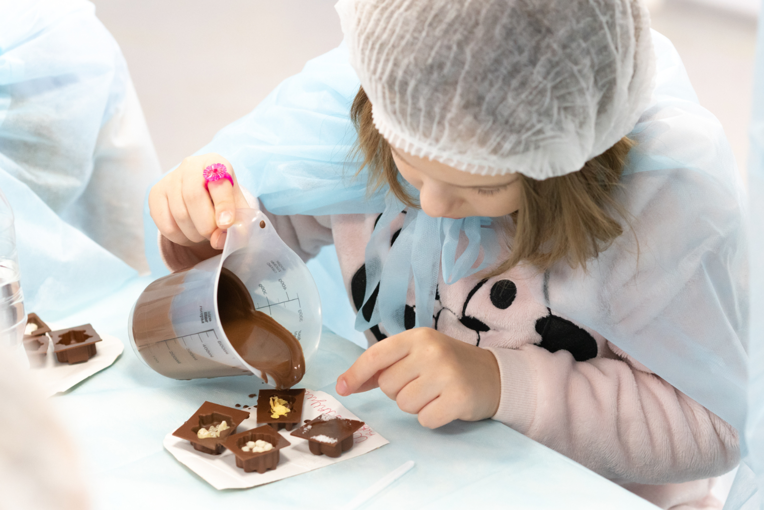 Criança realizando atividade com chocolate em ambiente escolar, explorando preparo e transformação do cacau em proposta pedagógica prática.