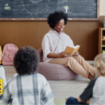 Professora realizando leitura compartilhada com crianças em sala de aula na educação infantil, estimulando linguagem e interação