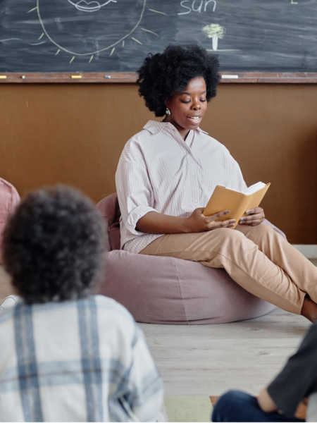 Professora realizando leitura compartilhada com crianças em sala de aula na educação infantil, estimulando linguagem e interação