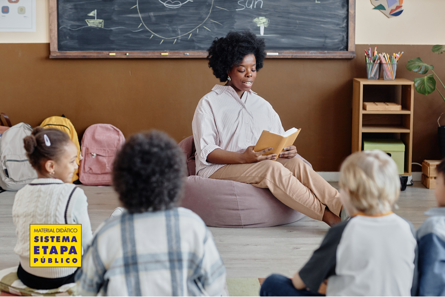 Professora realizando leitura compartilhada com crianças em sala de aula na educação infantil, estimulando linguagem e interação