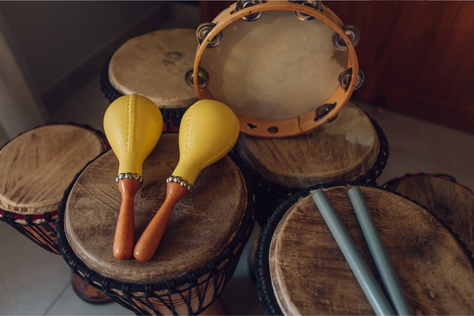 Instrumentos musicais como tambores, pandeiro e maracas utilizados em atividades culturais e educativas na escola para o dia dos povos indígenas.